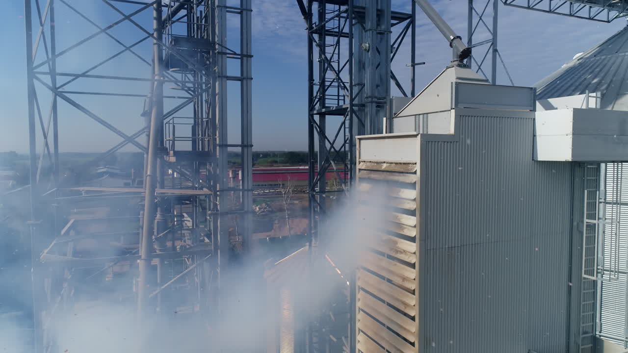 Smoke from industrial plant. Modern grain elevators from the air. Agricultural manufacturing pollutes the atmosphere. Aerial view.
