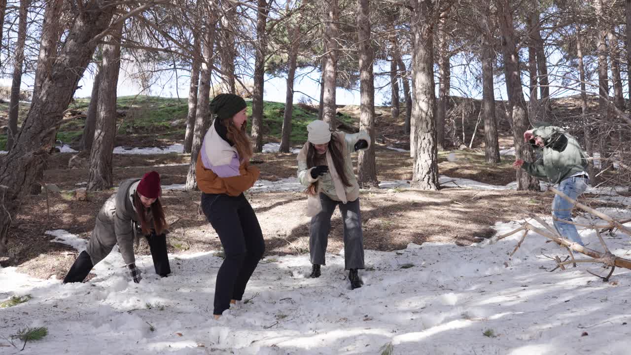 People having a snowball fight in a forest