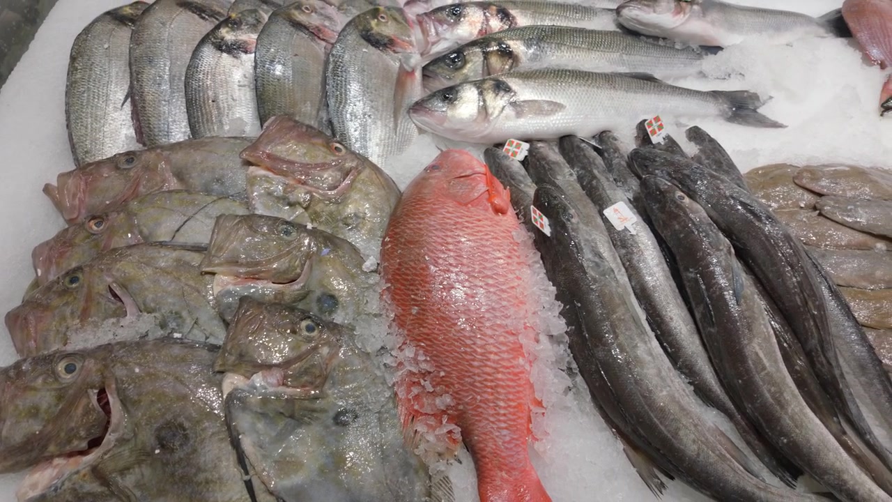 Close-up of assorted fresh fish including flatfish and red fish on ice at a seafood market, Cote d'Azur, France