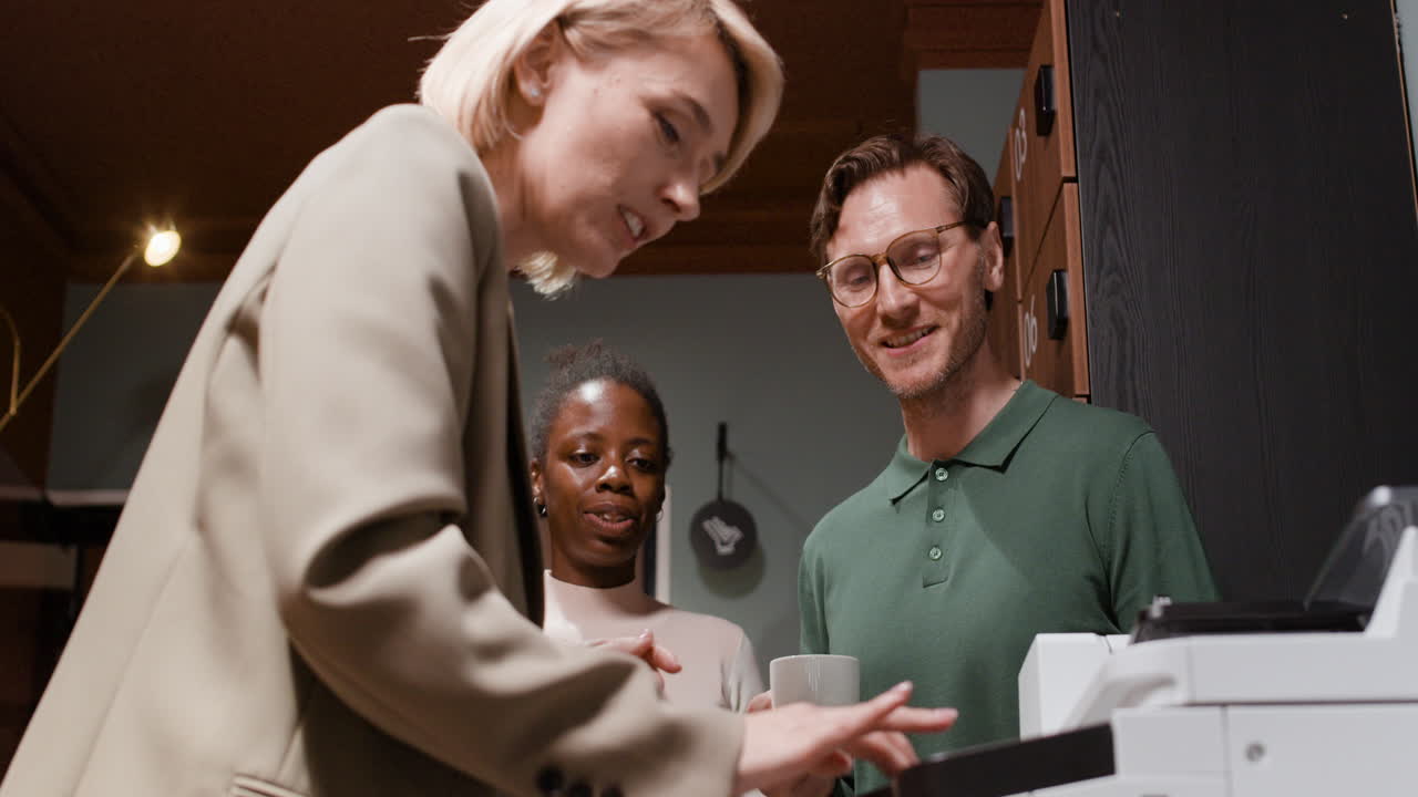 Colleagues collaborating and conversing at the office printer