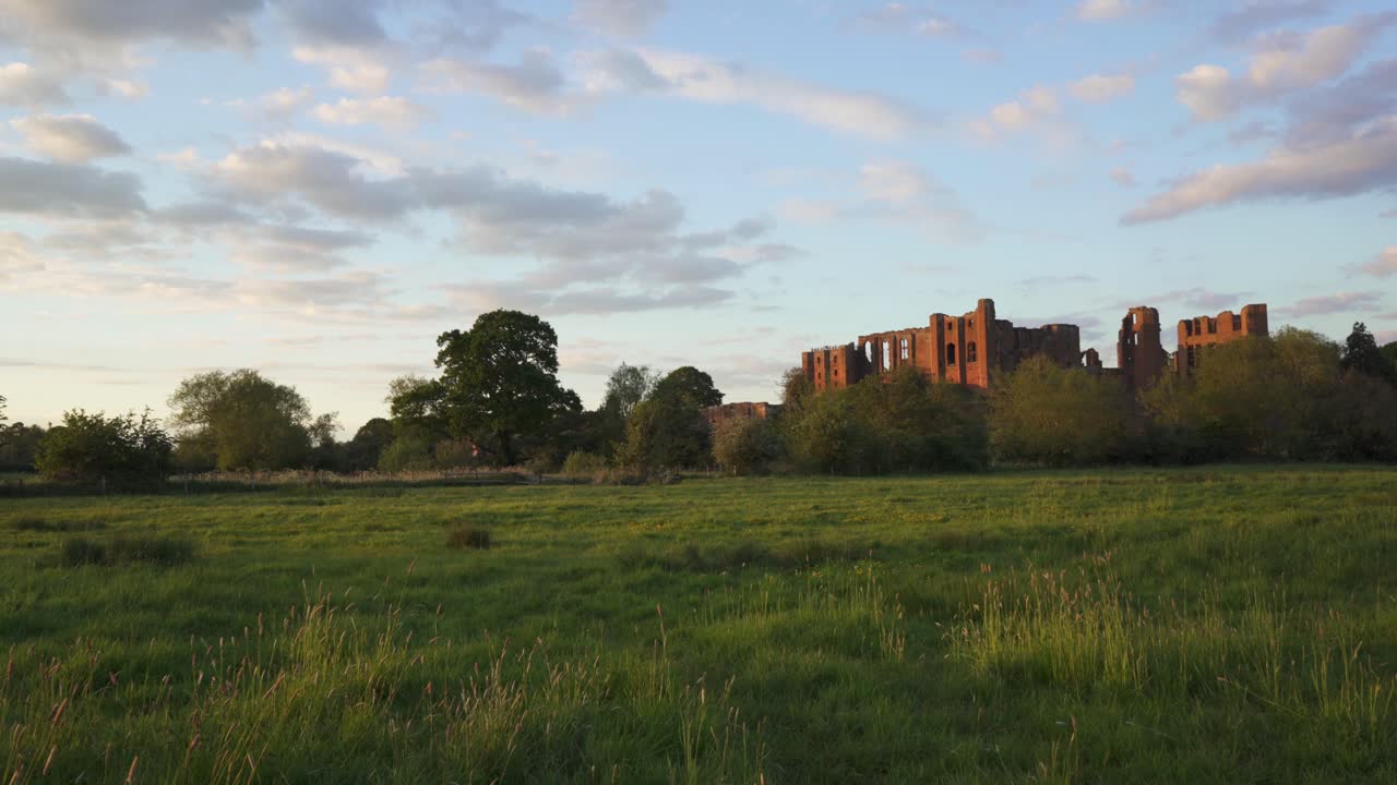 noche de verano inglesa perfecta con una panorámica lenta que muestra las poderosas ruinas del castillo de kenilworth justo antes del atardecer