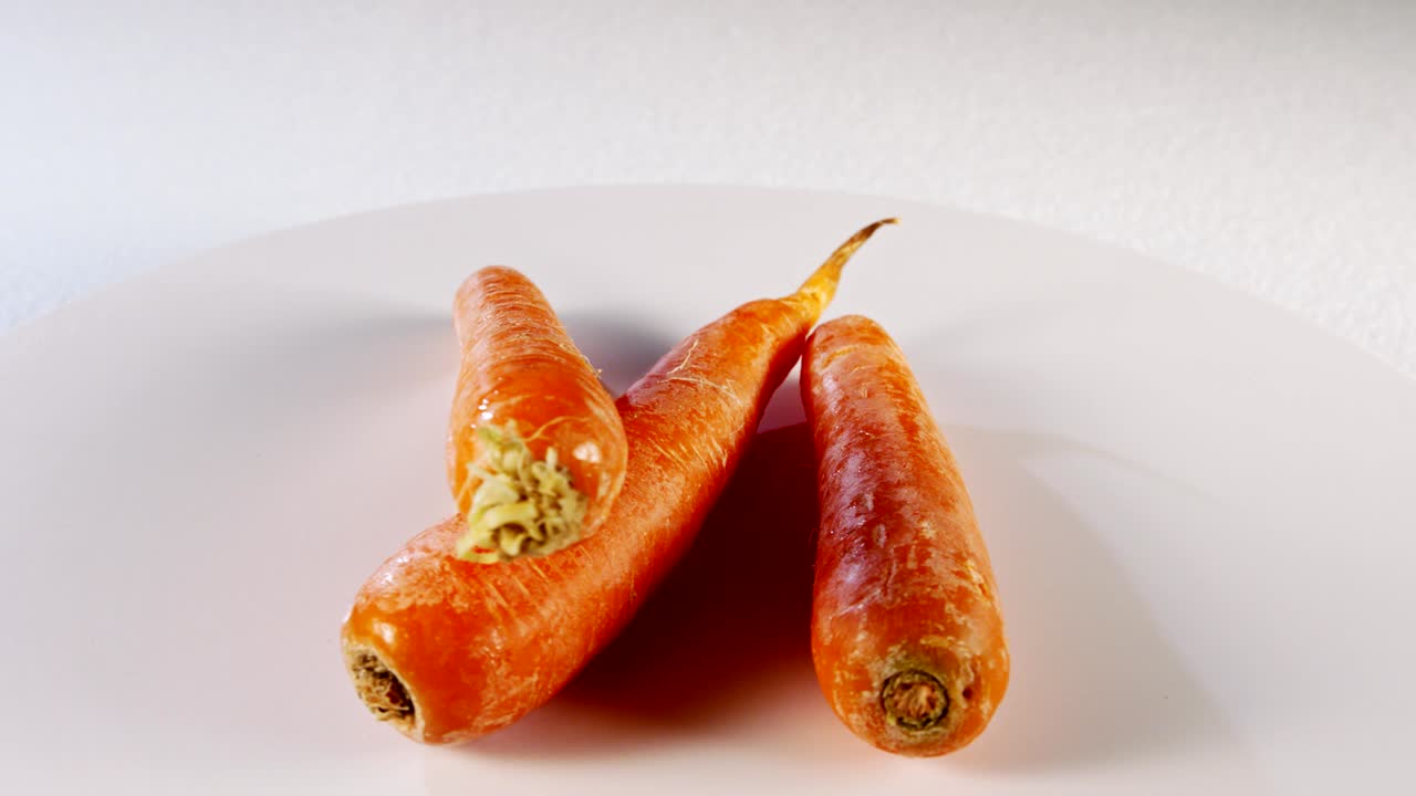 zanahorias girando sobre un fondo blanco