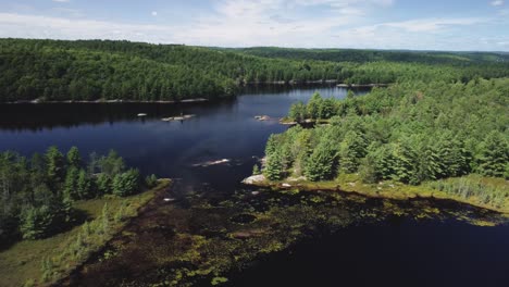 Crane-drone-view-of-a-remote-lake-surrounded-by-woods-and-trees-hb01
