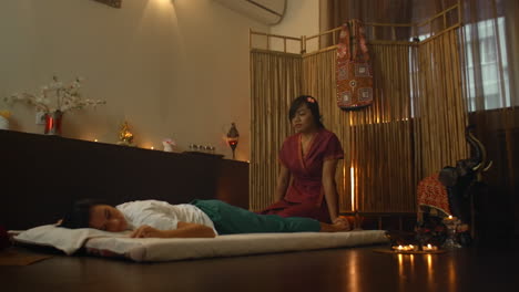 therapist giving a traditional chinese massage of feet. professional therapist giving a traditional chinese massage of feet to a woman in a chinese therapeutic