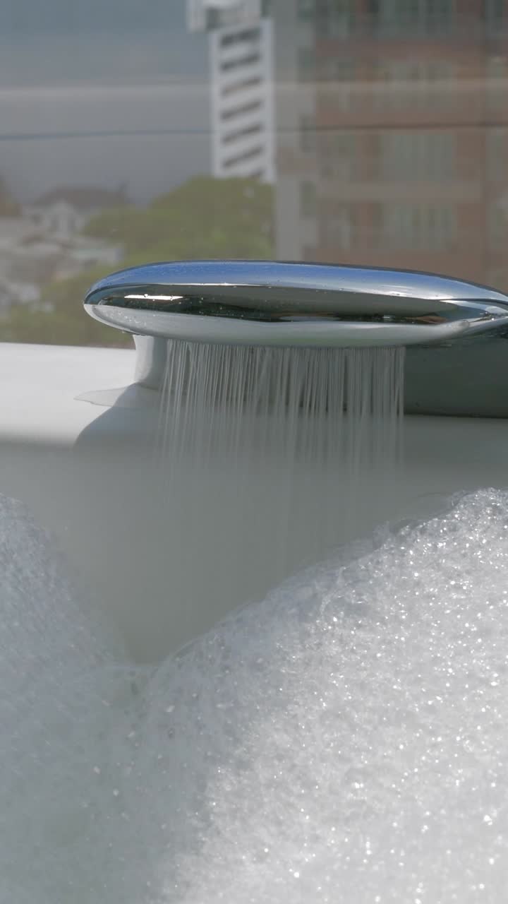 Primo piano di un rubinetto della vasca da bagno che si riempie di bolle