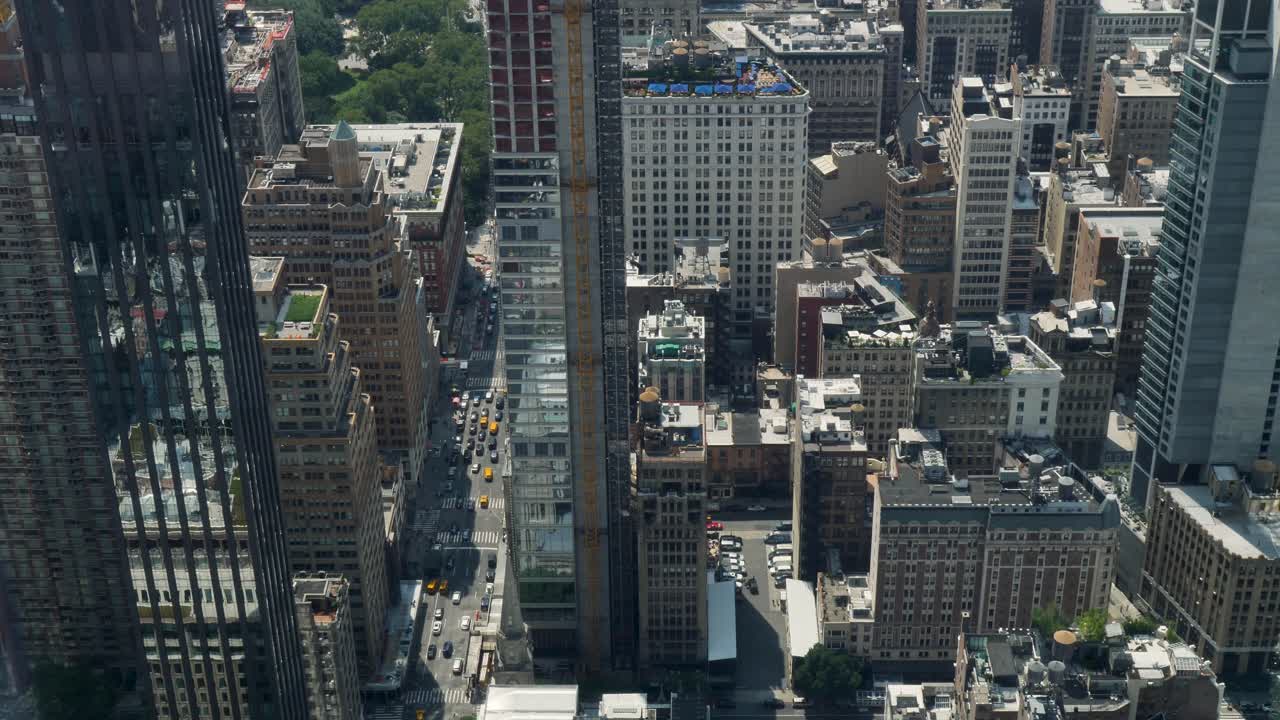 Slow motion landscape of busy city intersection with cars taxi traffic transport and buildings towers skyscrapers skyline Manhattan New York USA America travel urban infrastructure