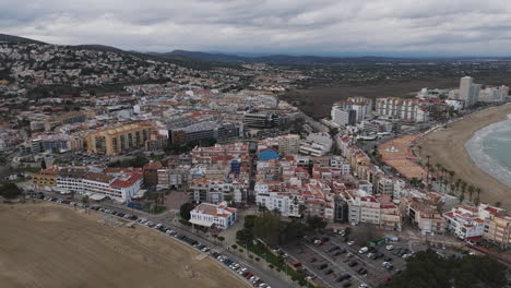 overhead aerial showing full beach line and city edge of peniscola under overcast sky