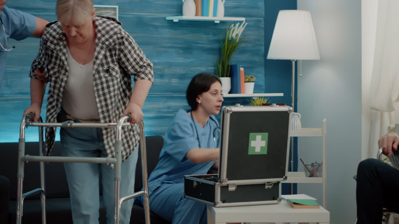 Disabled woman walking with walk frame while nurse giving assistance