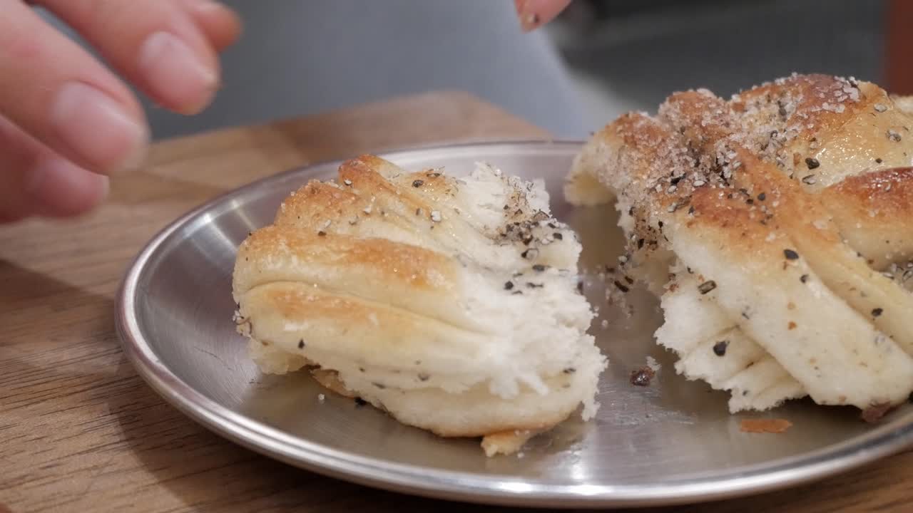 Freshly baked cardamom buns on metal plate, close-up in cozy indoor setting