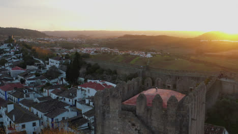 un sobrevuelo aéreo de un castillo en óbidos, portugal a la hora dorada