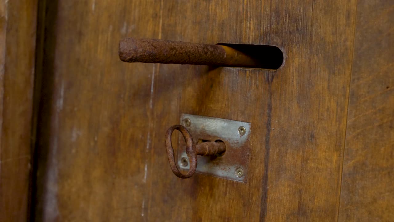 녹슨 볼트와 열쇠가 있는 무거운 나무 문