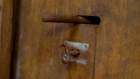 Heavy-wooden-door-with-rusted-bolt-and-key