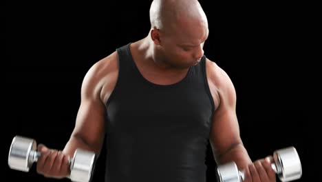 serious muscular man lifting dumbbells