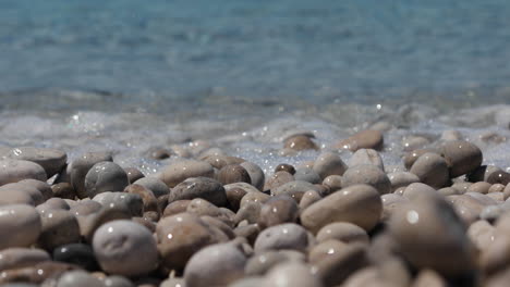 Clean-sea-water-washing-shiny-pebbles-on-beach,-seascape-texture,-vacation-concept