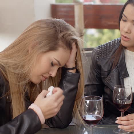 paar traurige frauen, die wein trinken