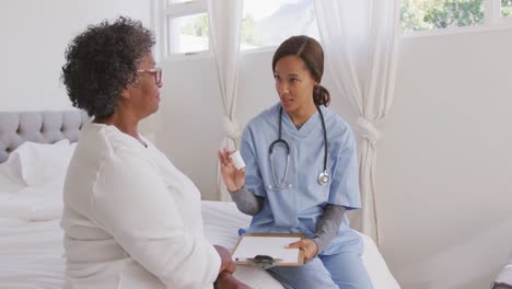 mixed race woman being visited at home by a nurse. social distancing and self isolation in quarantin