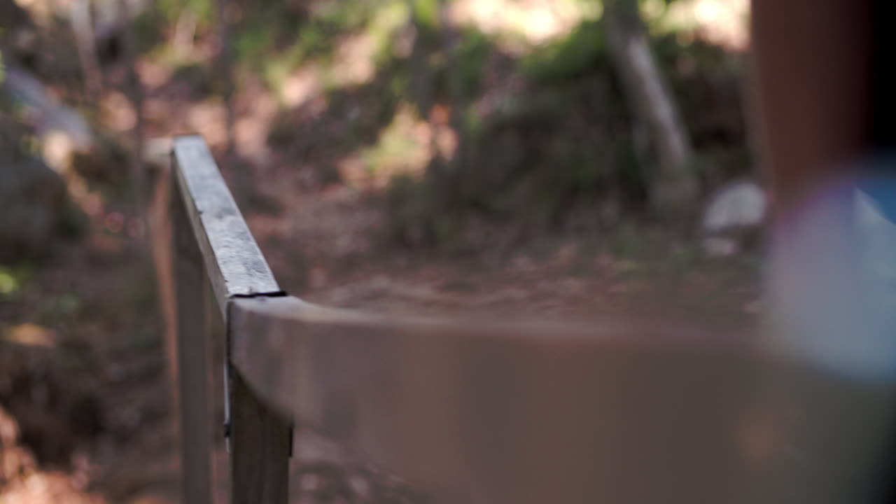 People walking over a small wooden bridge, close up of hands