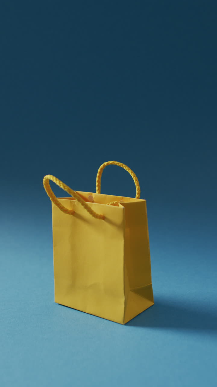 video vertical de una bolsa de compras de papel sobre un fondo azul