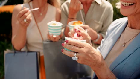 mature women with shopping bags eating ice-cream in the city