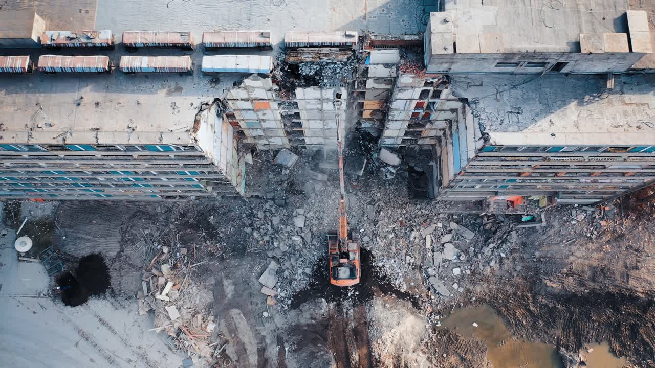 Demolition of building for new construction by excavator bucket. Demolition of the house. City development. View from above