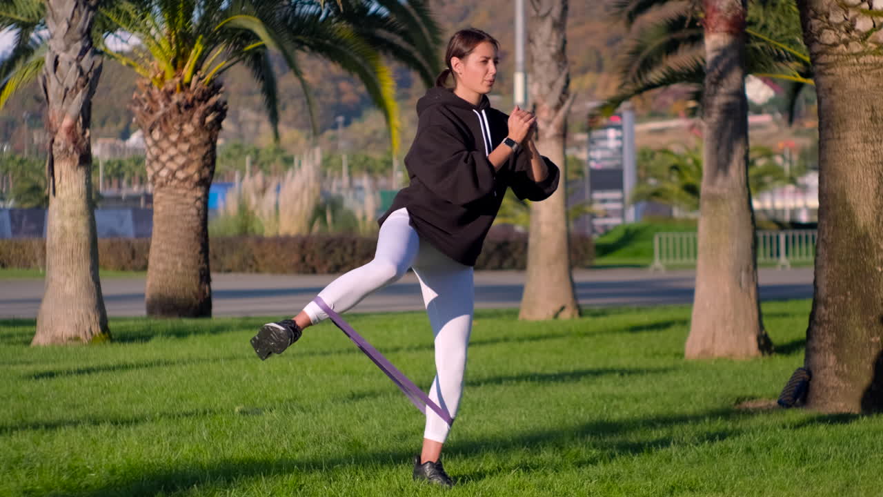 Woman exercising with resistance band in a park