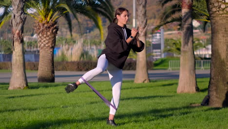 mujer haciendo ejercicio con banda de resistencia en un parque