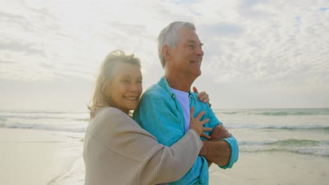 Active-senior-Caucasian-couple-embracing-each-other-on-the-beach-4k