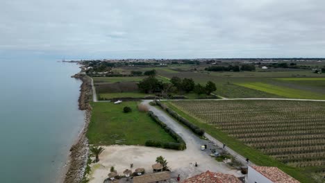 people ride bicycles near farmland at the village of loix in île de ré island in western france, aerial flyover shot