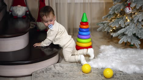 baby playing with toys near christmas tree