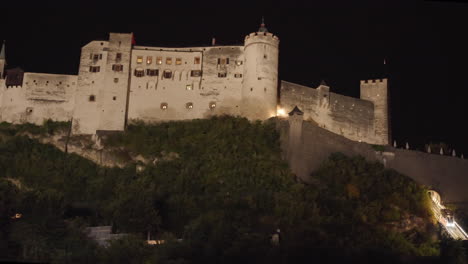 a wide-open view of fortress hohensalzburg, salzburg, austria at night when the artificial lighting is fully covered the castle, and its looks very beautiful