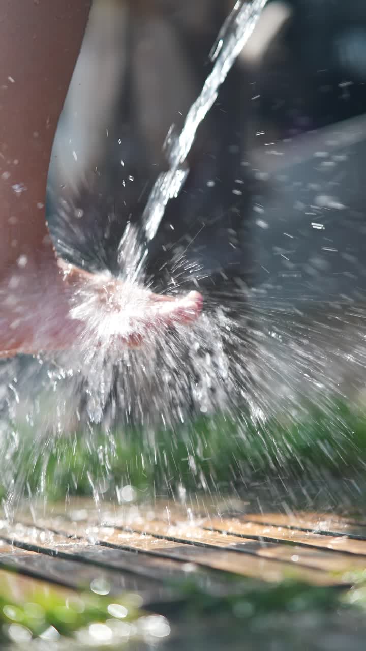 Child splashing water on feet and hand