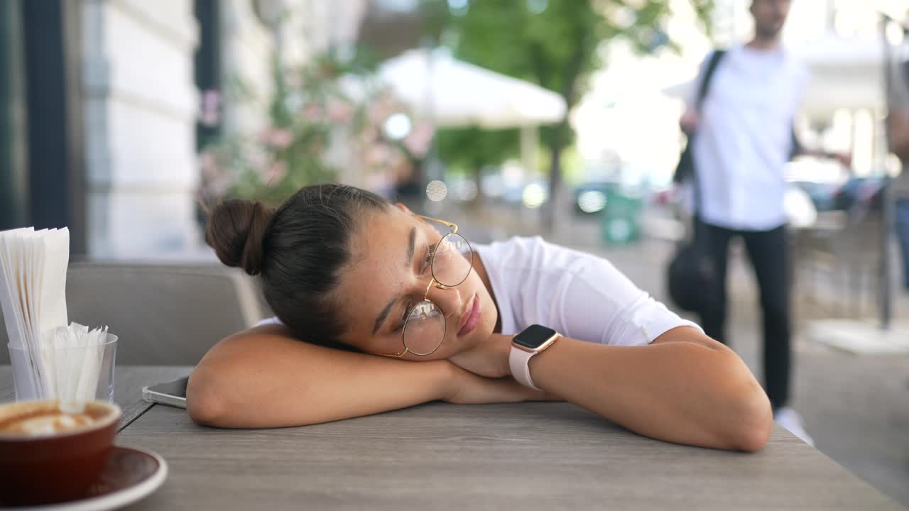 un adolescente cansado tomando una siesta en un café al aire libre