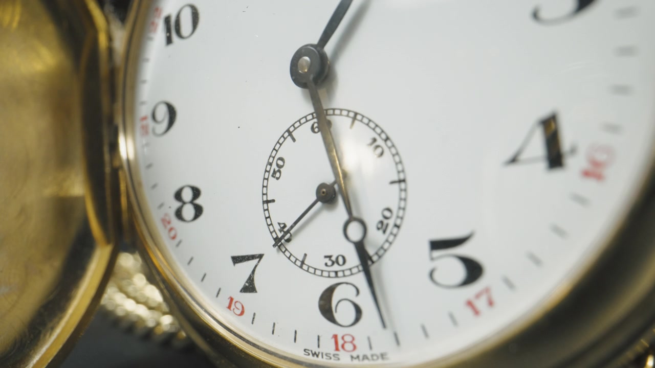 The second hand an antique golden stopwatch ticking for about 57 seconds. Macro close up.