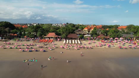 People-Relaxing-on-Double-Six-Beach-in-Seminyak,-Bali,-Indonesia---Aerial-Push-Back-Rising-Shot