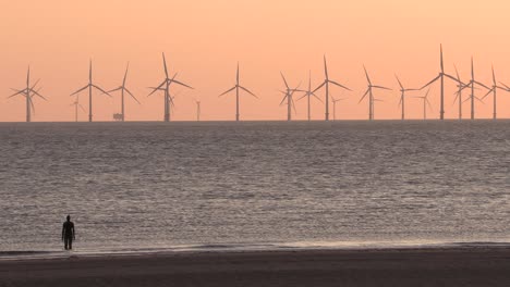 vista aérea de una granja de turbinas eólicas al atardecer para producir energía limpia, renovable y sostenible.