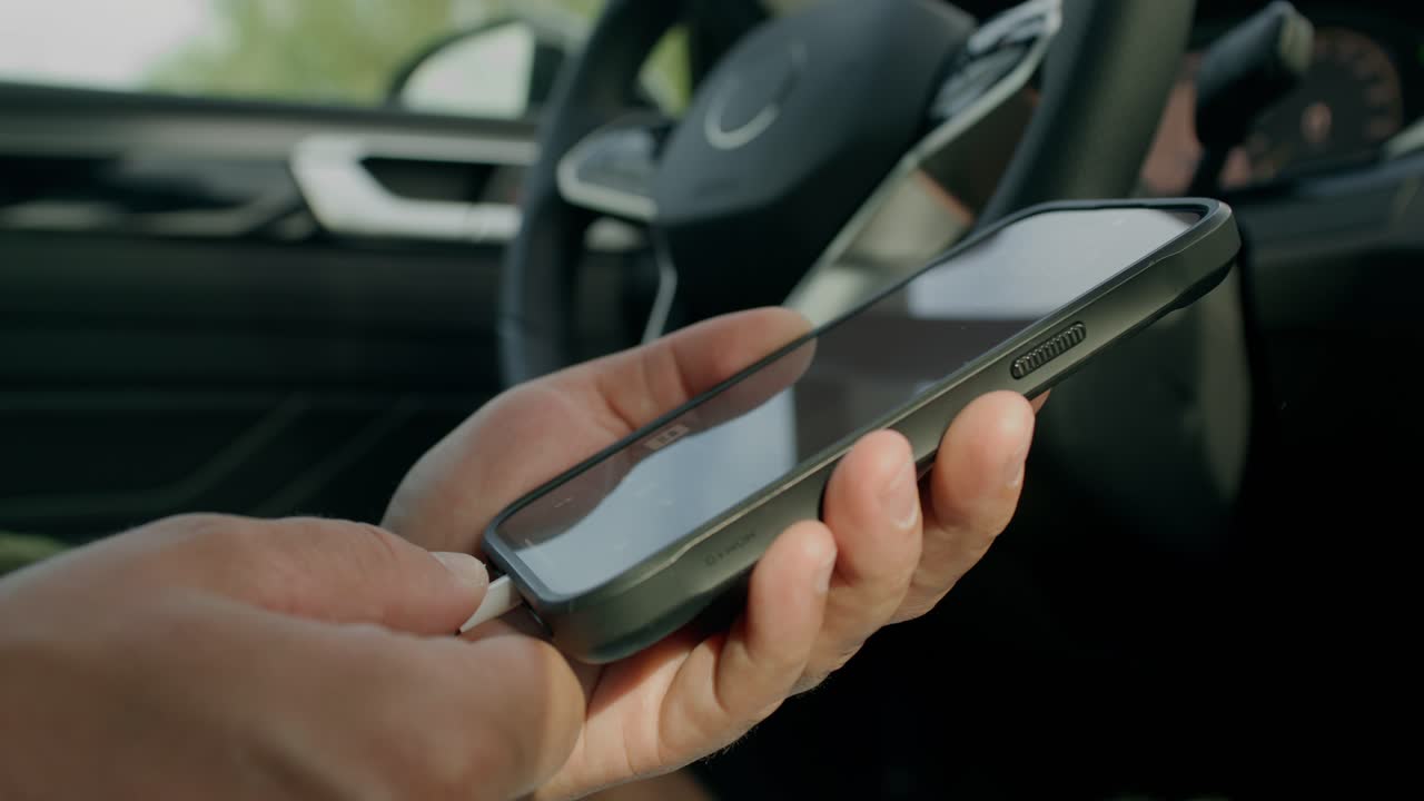 persona que usa un teléfono mientras conduce un automóvil