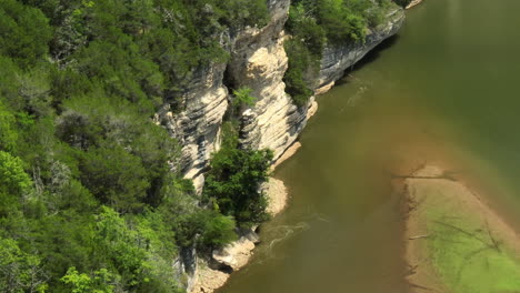 beaver lake with rocky cliffs and lush greenery on a sunny day, aerial view