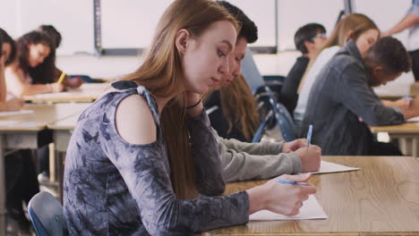 Gruppe-Von-College-Studenten-Am-Schreibtisch-Im-Klassenzimmer,-Die-Einen-Test-Ablegen