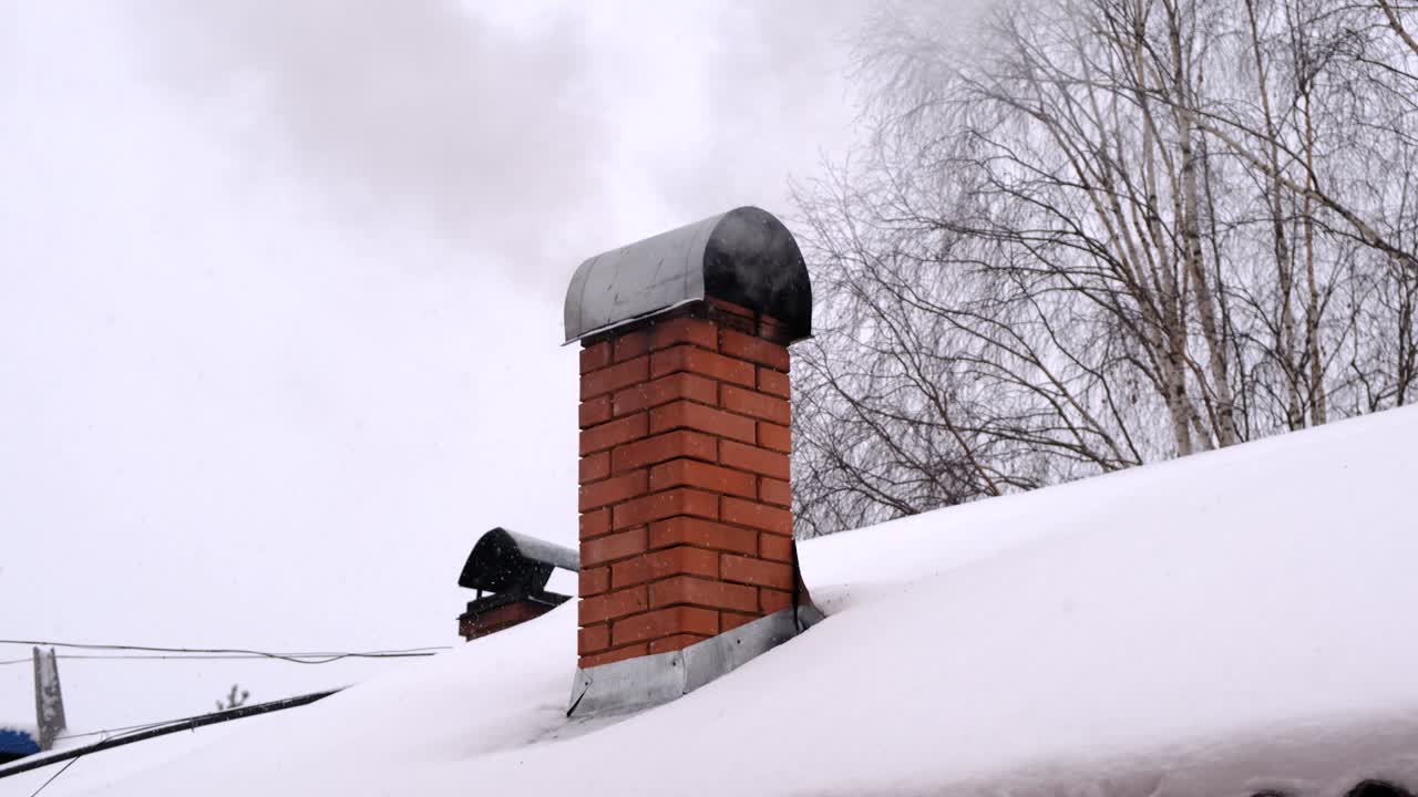 Smoke from the chimney, heating. Winter cloudy day with snow