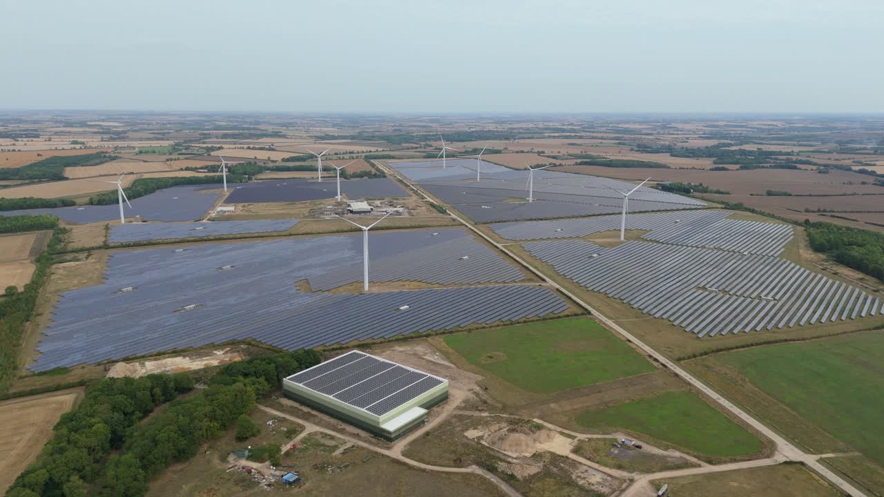 Aerial drone view of renewable energy power plant with wind turbines and solar panels at sunset in Wellingborough United Kingdom
