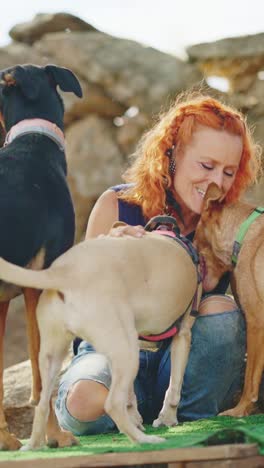woman enjoying playful moments with her dogs outdoors
