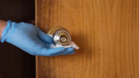 cleaning a door handle with gloves