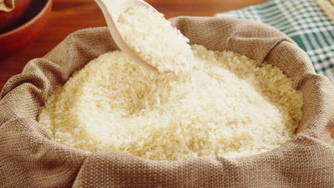scooping rice grains from a burlap sack