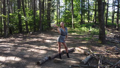 Young-healthy-caucasian-girl-kissing-toward-camera-inside-a-magical-forest-on-a-sunny-day,-early-summer