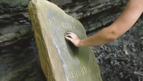 person touching a carved stone