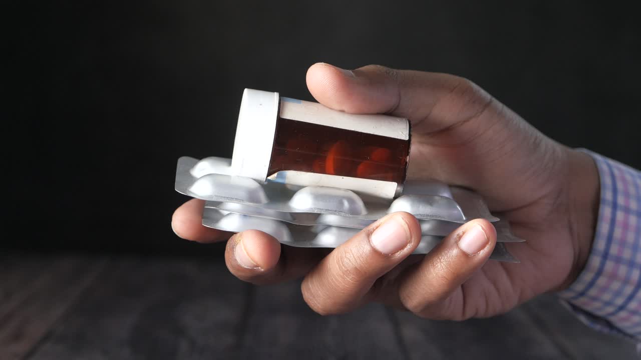 손으로 약병 병과 블리스터 패키지를 들고