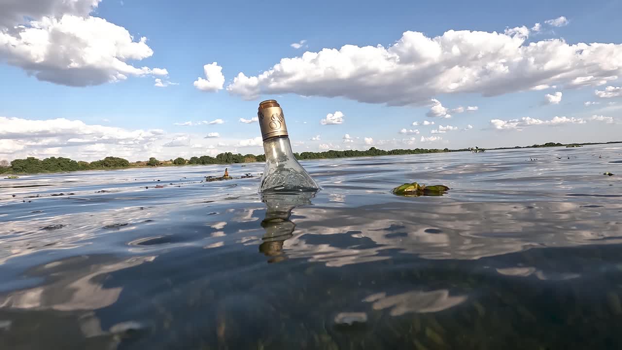 botella de vidrio, basura flotando en el río san francisco contaminando