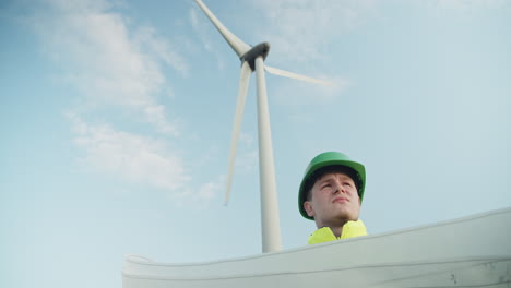 young technician holding a roll of construction plans