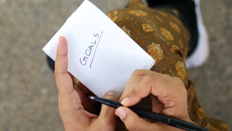 Las-Mujeres-Escriben-Metas-A-Mano-En-Un-Bloc-De-Notas.