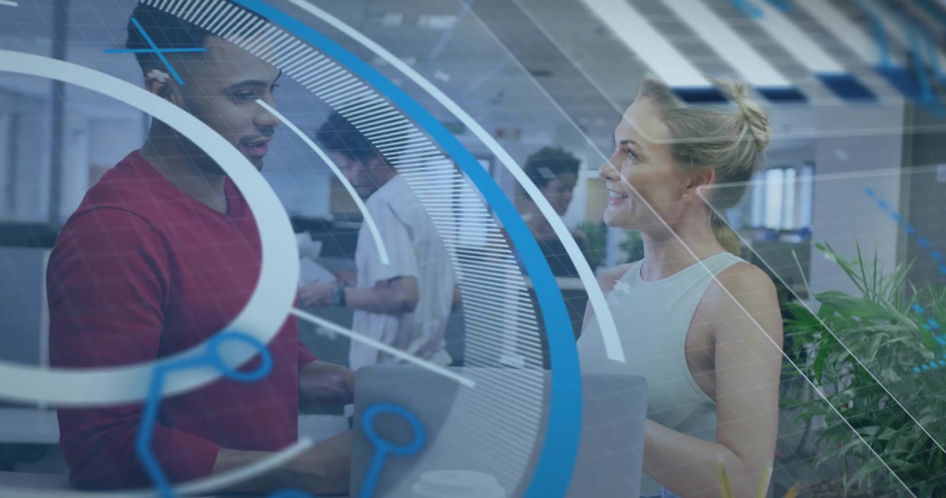 Man pointing phone toward laptop, woman synchronizing, graphics swirling technology collaboration